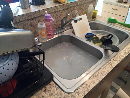 Technician preparing to install a new garbage disposal under a kitchen sink in st cloud florida